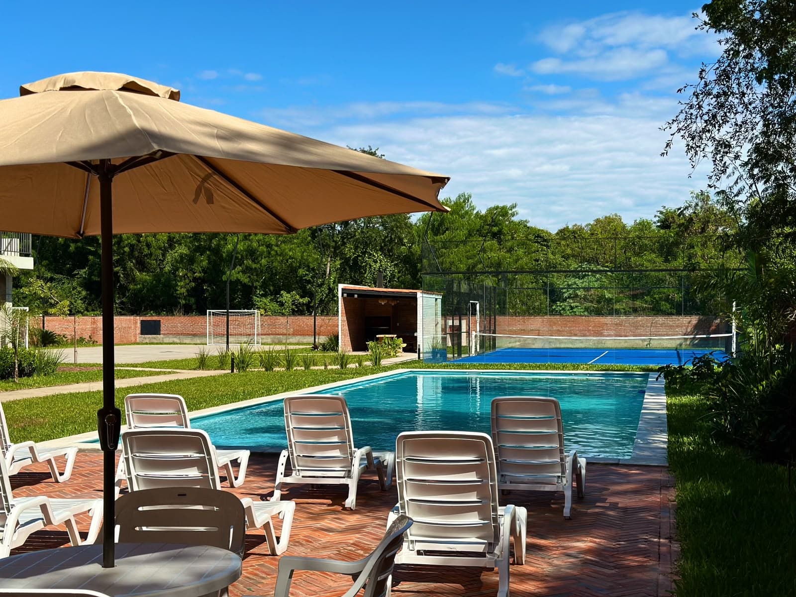 Reposeras y sombrillas al borde de la piscina